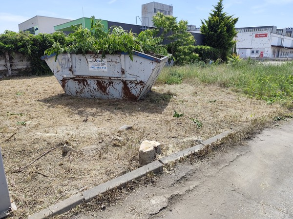 Veľkoobjemový kontajner s pokosenou zeleňou na vyčistenom pozemku